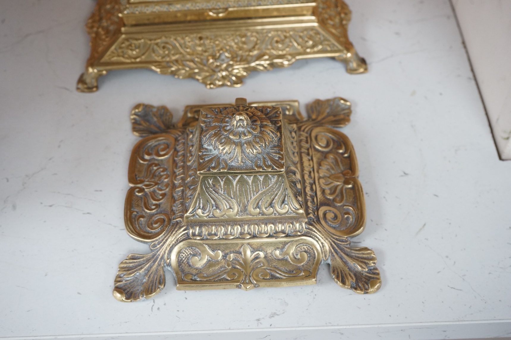 A decorative brass stamp box and a similar inkwell, largest 22cm wide